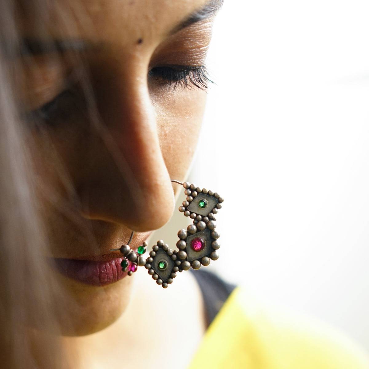 a close up of a person wearing a pair of earrings