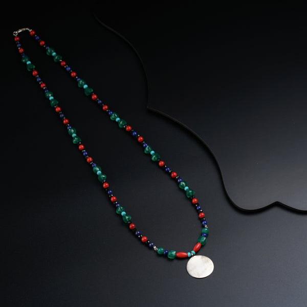 a necklace with a white disc on a black background