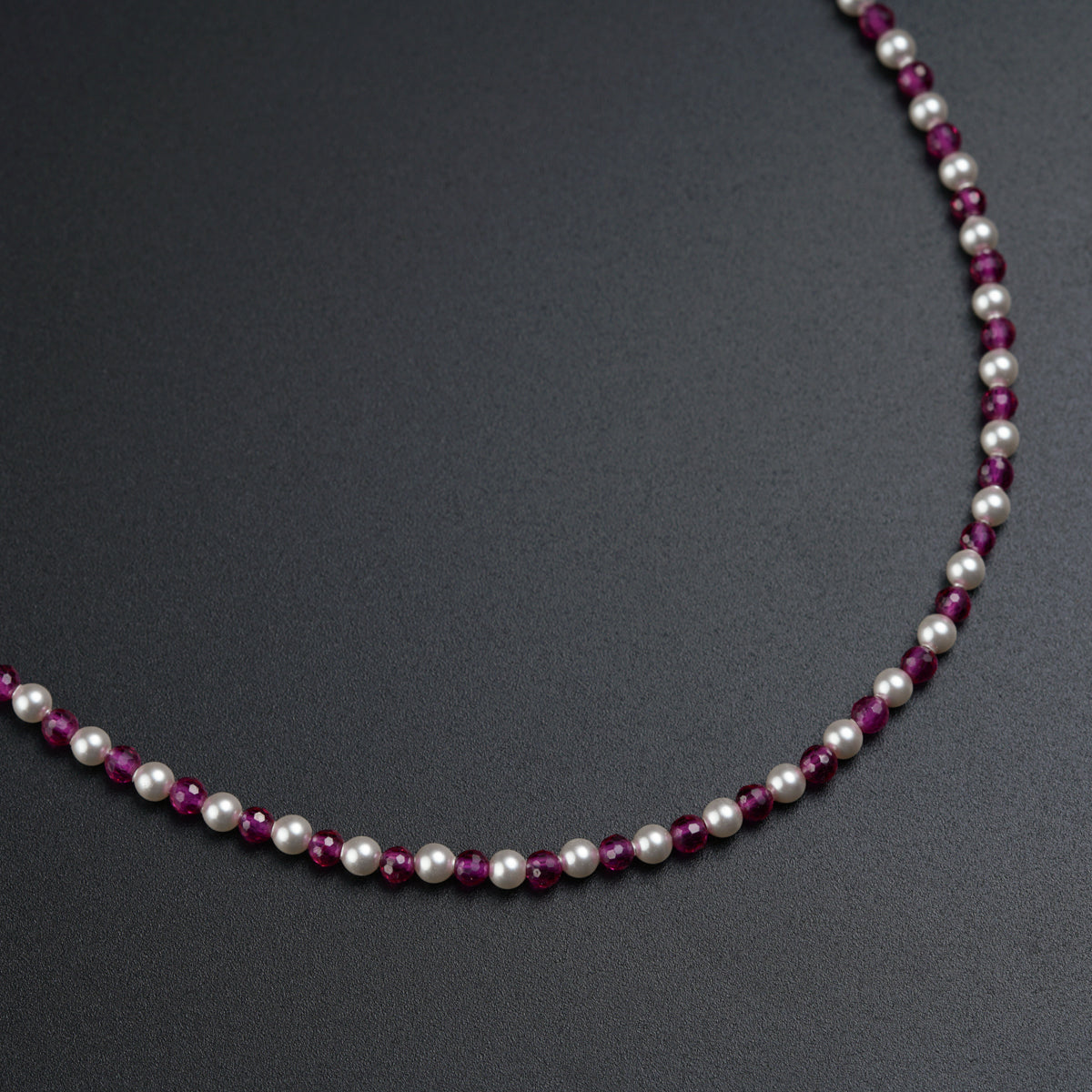 a necklace made of pearls and purple glass beads