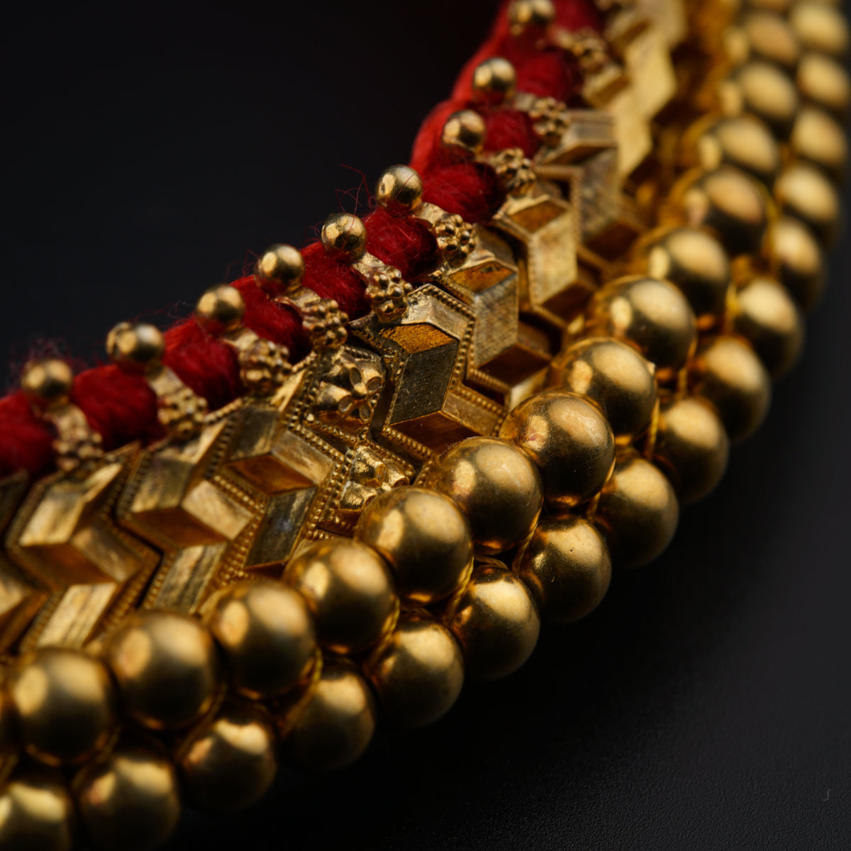a close up of a gold and red necklace