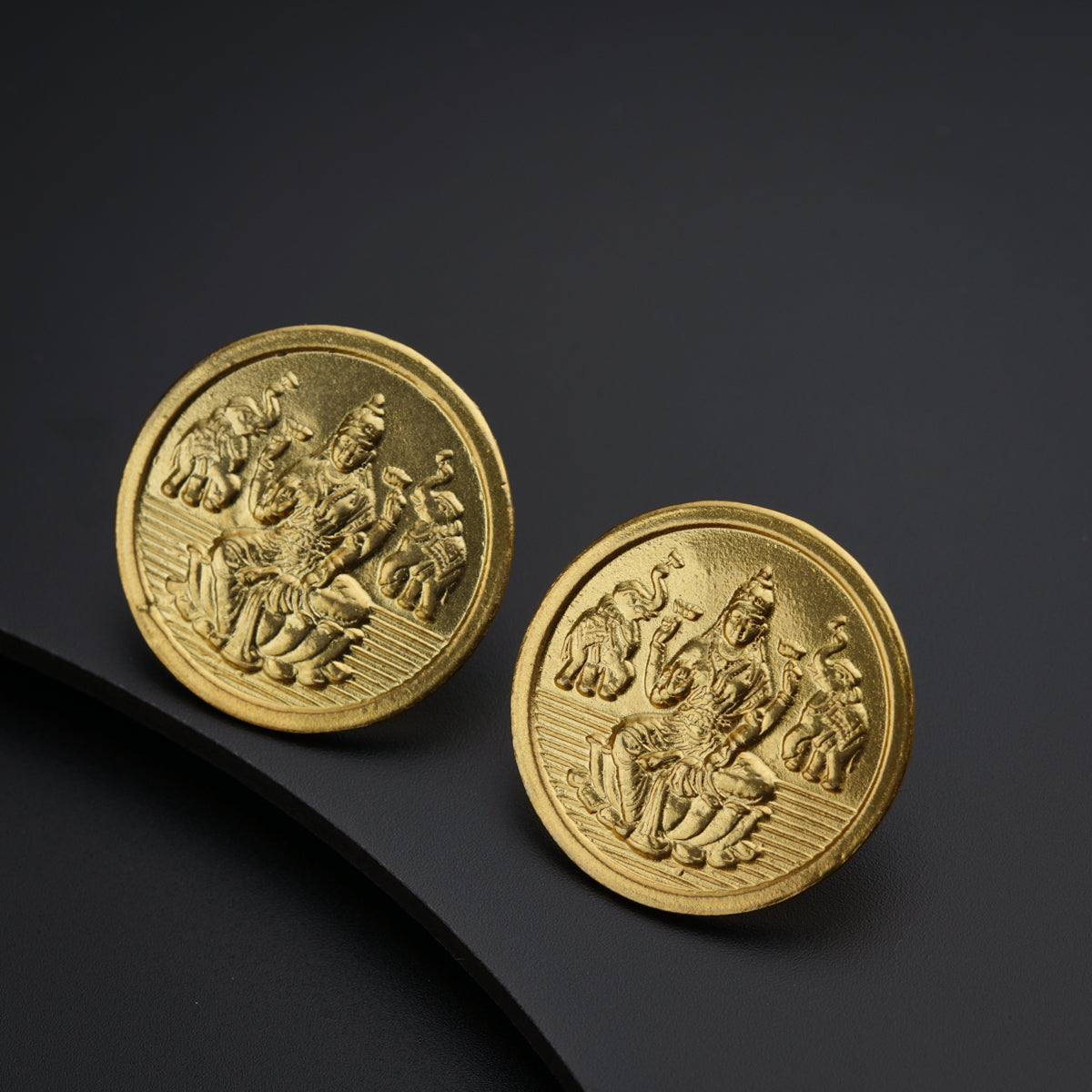 a close up of two gold coins on a black surface