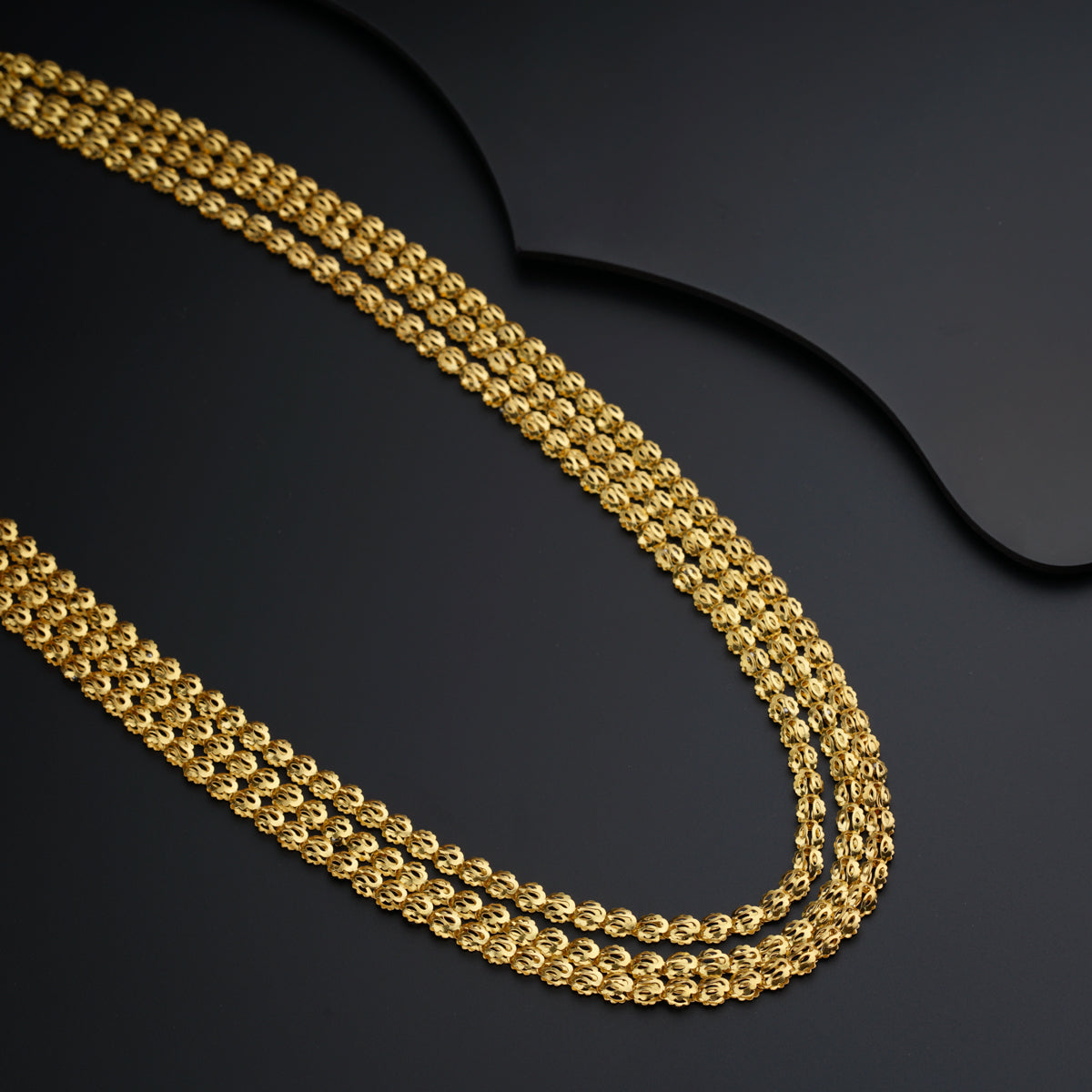 a gold chain on a black surface