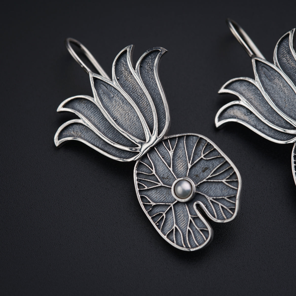 a pair of silver brooches sitting on top of a table