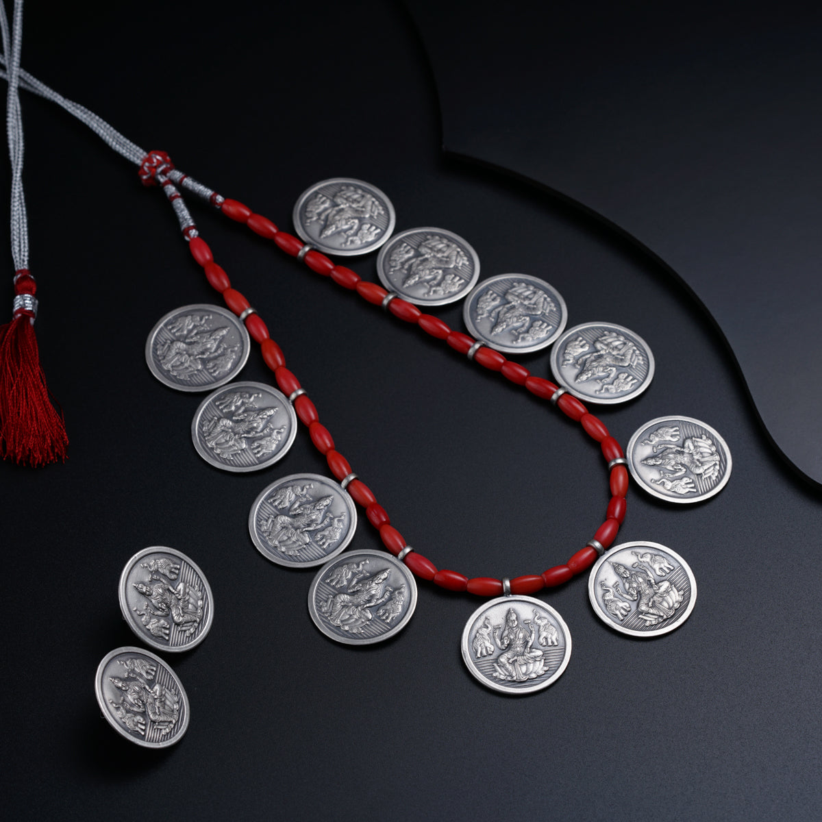 a necklace made of silver coins and a red string