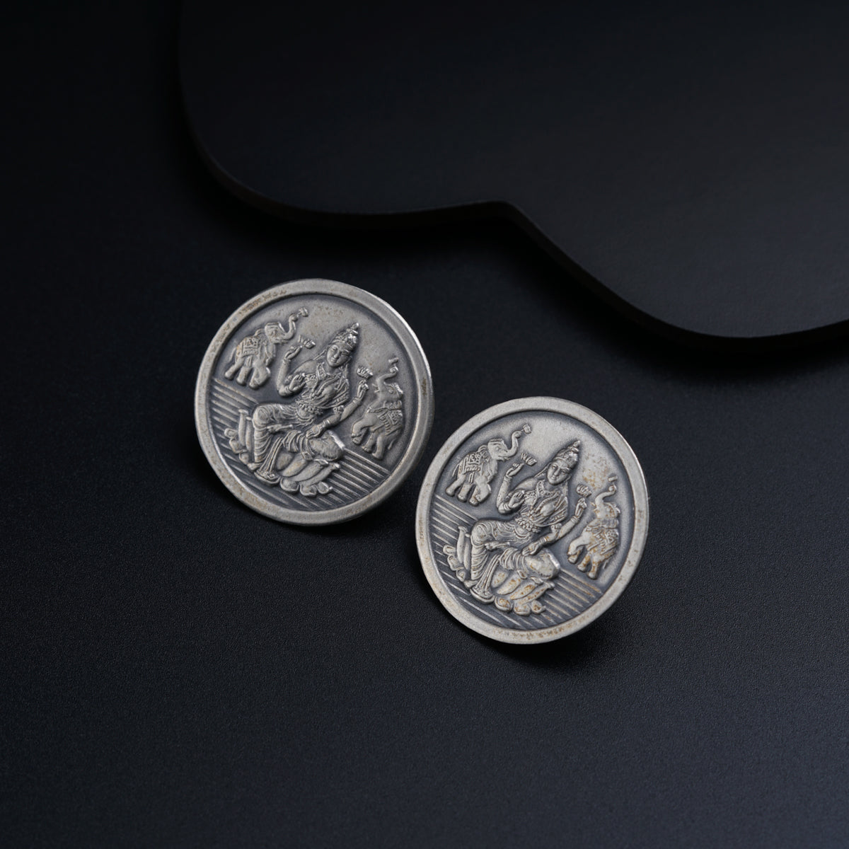 a pair of silver coin sitting on top of a black surface