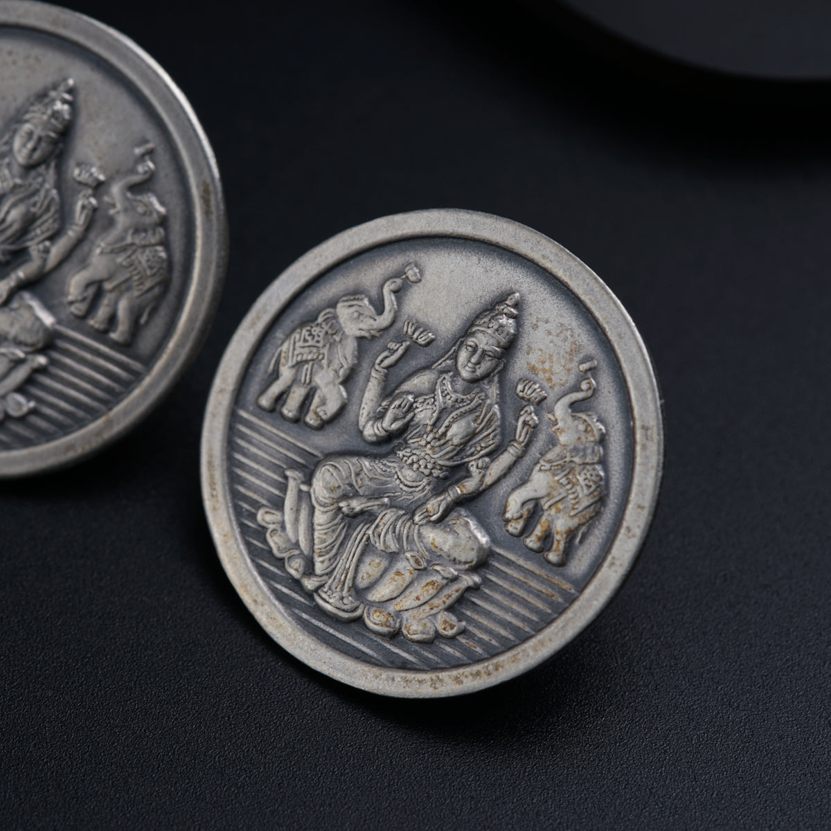 a close up of two silver coins on a black surface