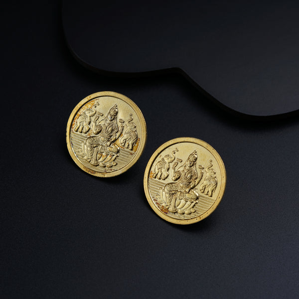 a pair of gold coins sitting on top of a black surface