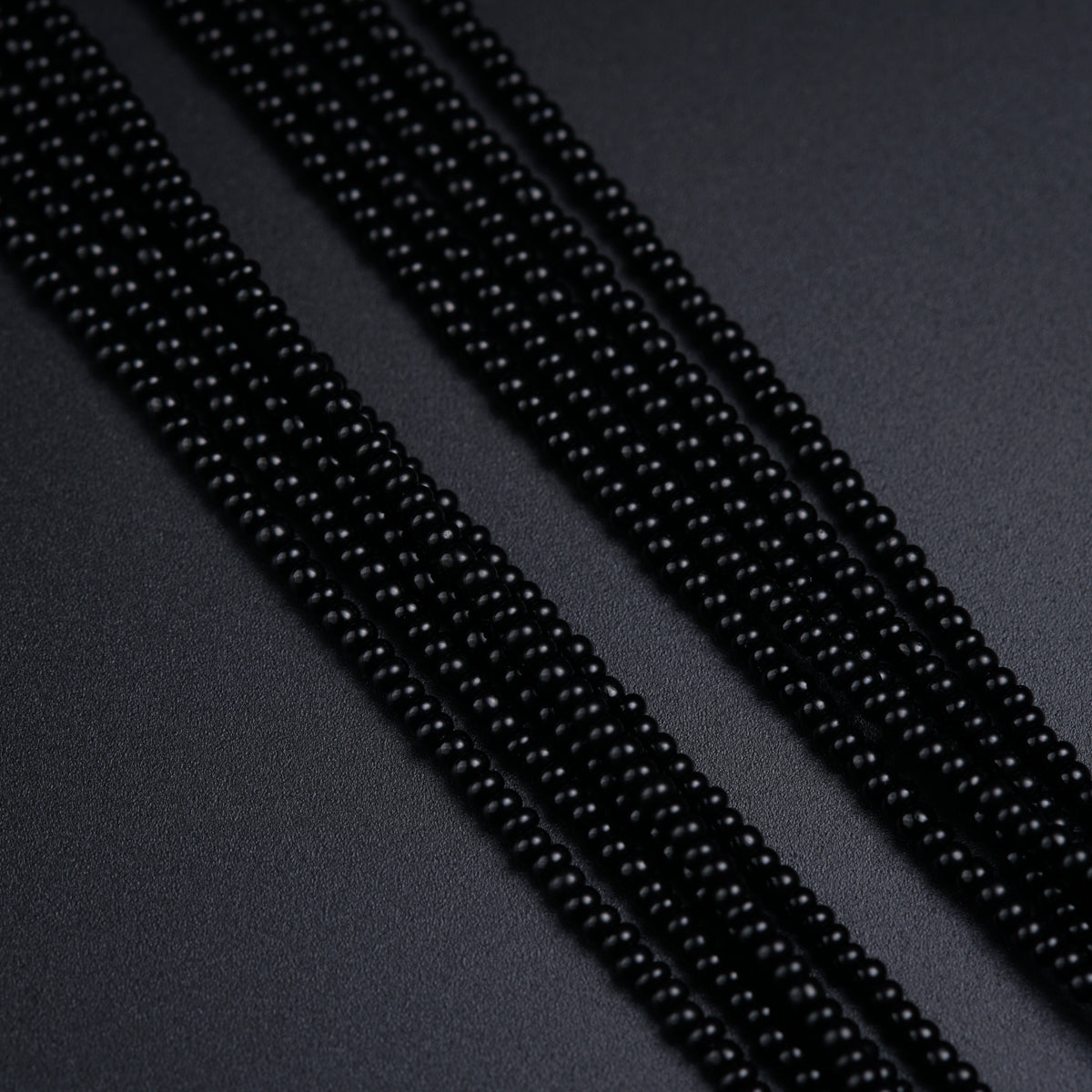 a close up of beads on a black surface