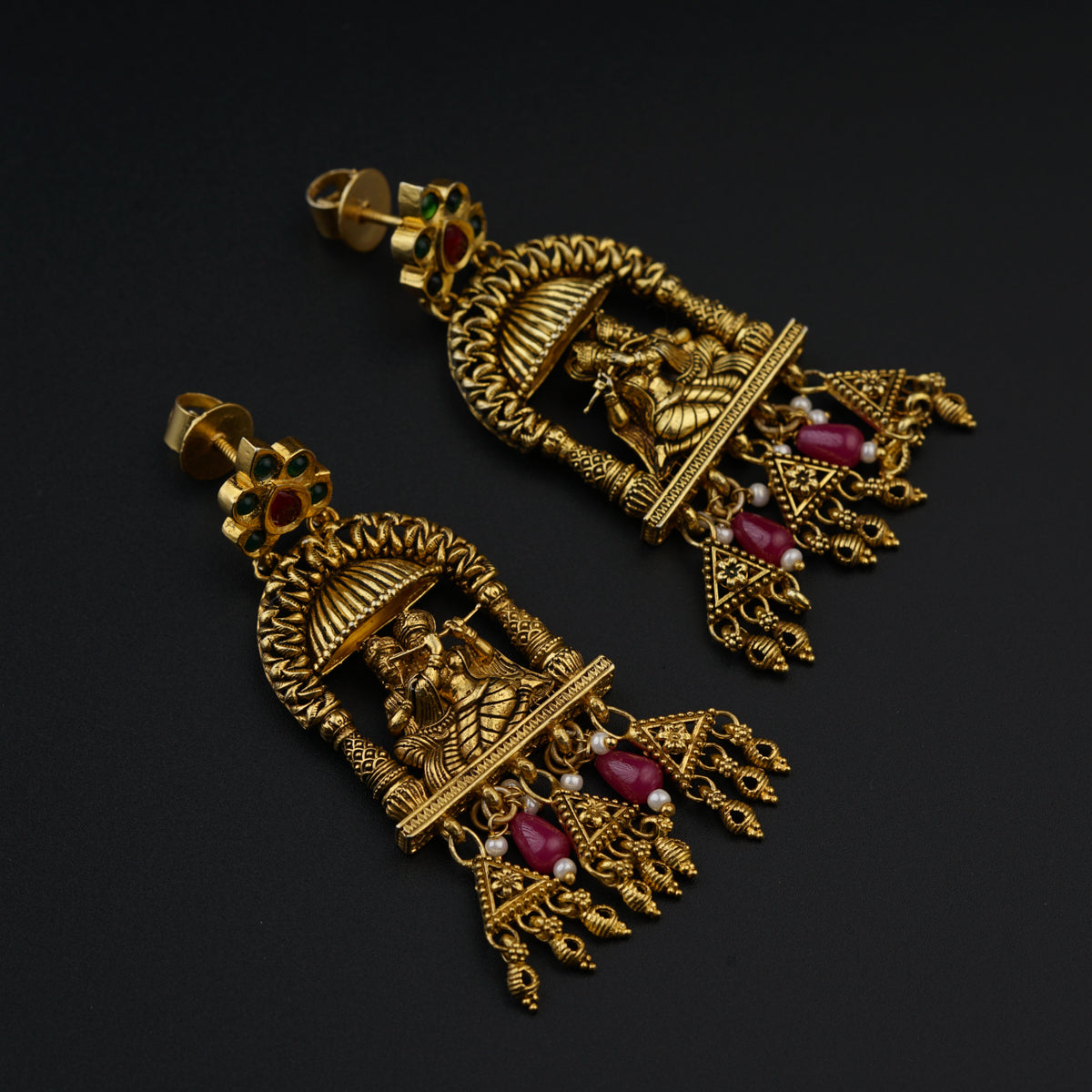 a pair of gold earrings with garnets and pearls