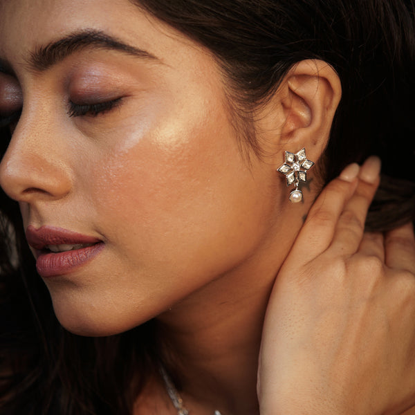 Woman wearing silver leaf jewelry with pearl earrings
