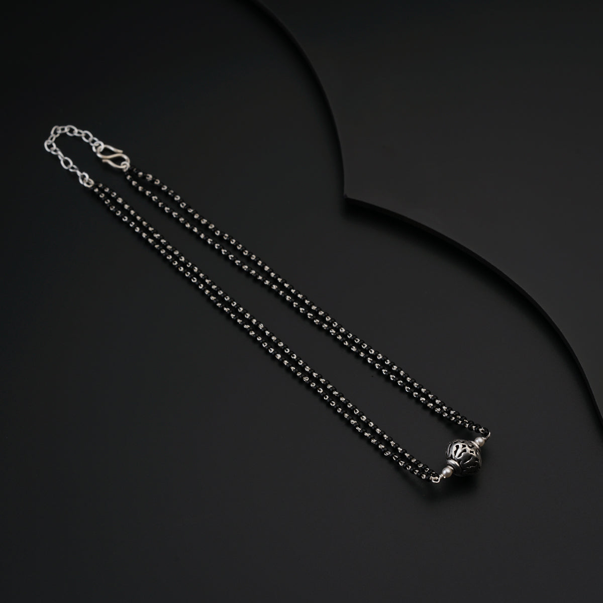 a black and silver necklace with a cross on it