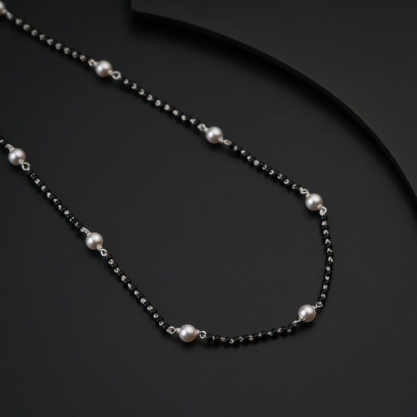 a black and white necklace with pearls on it