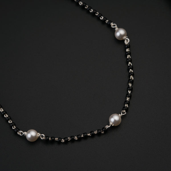 a black and white necklace with pearls on it