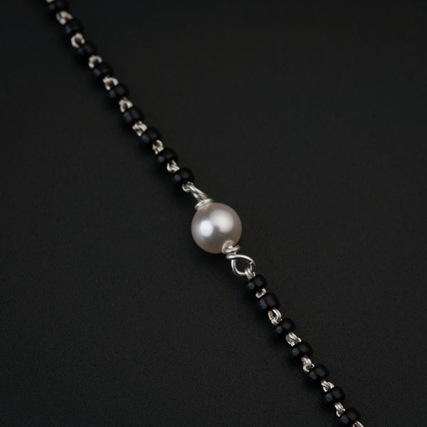 a black and white necklace with a pearl on it
