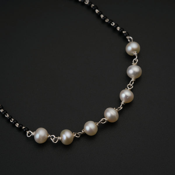 a necklace with pearls on a black background