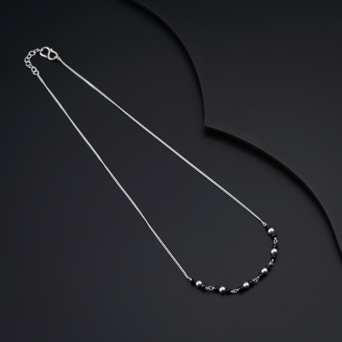 a black and white necklace on a black background