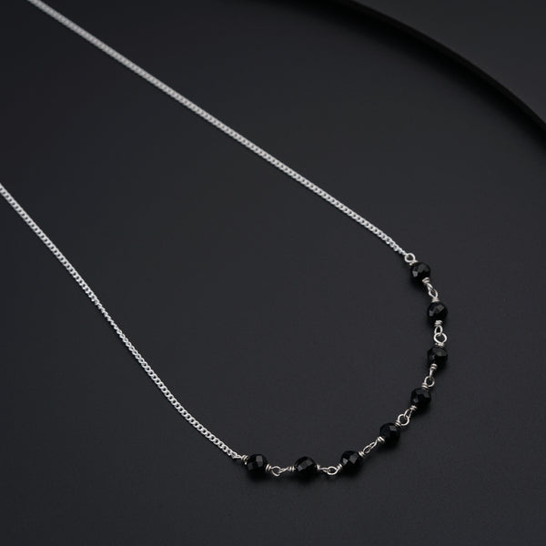 a black beaded necklace on a black surface