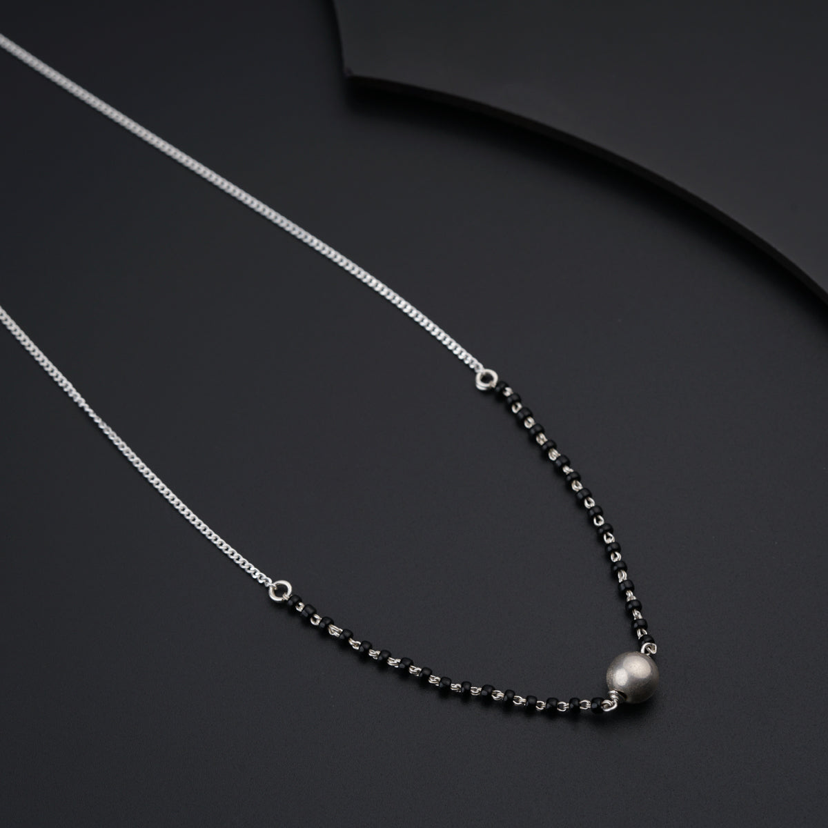 a black and white necklace with a pearl on it