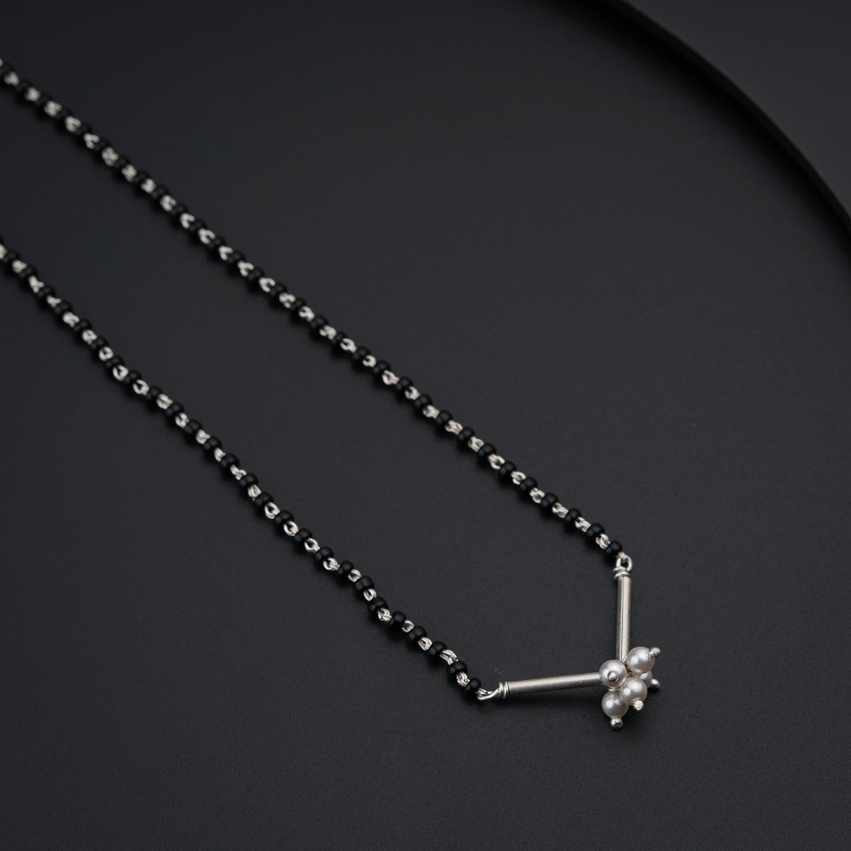 a black and white necklace with a cross on it