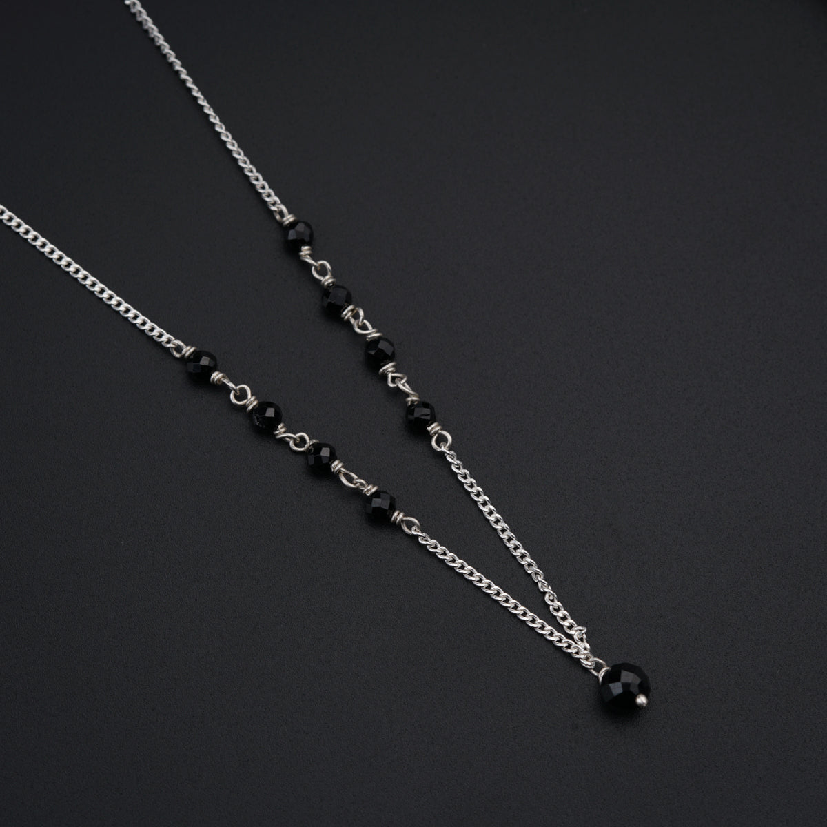 a couple of black beads on a silver chain