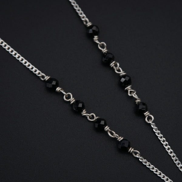 a close up of a black and silver necklace