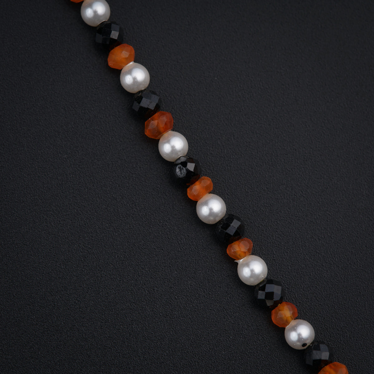 a close up of a necklace with pearls