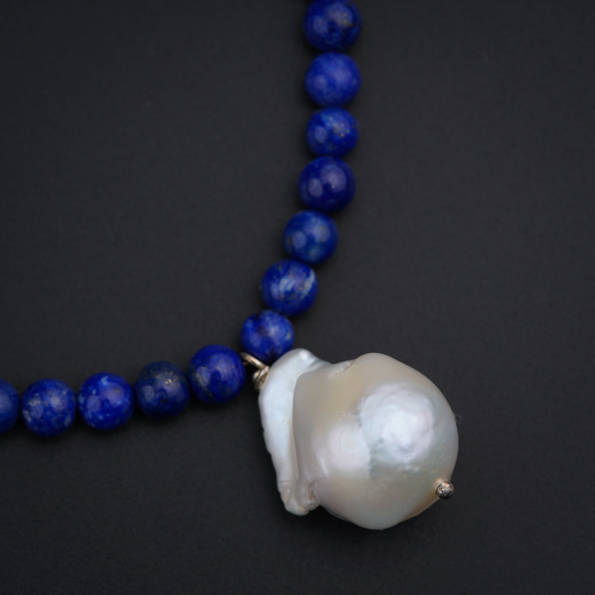 a necklace with a white shell and blue beads
