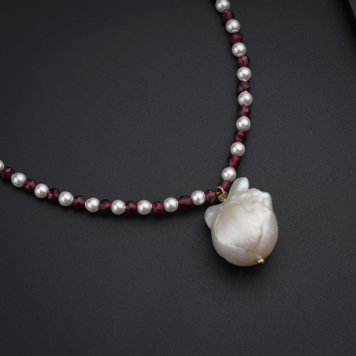 a necklace with a white flower and pearls