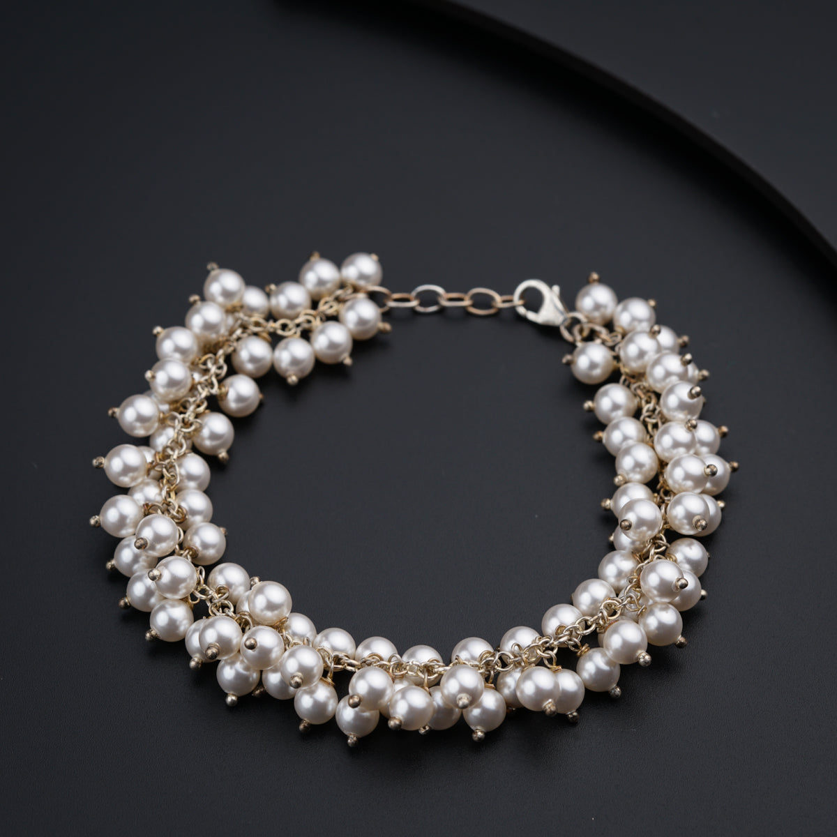 a close up of a bracelet with pearls