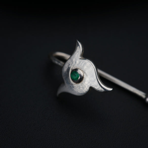 a close up of a ring with a green stone