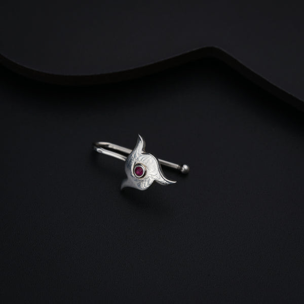 a close up of a silver ring with a red stone