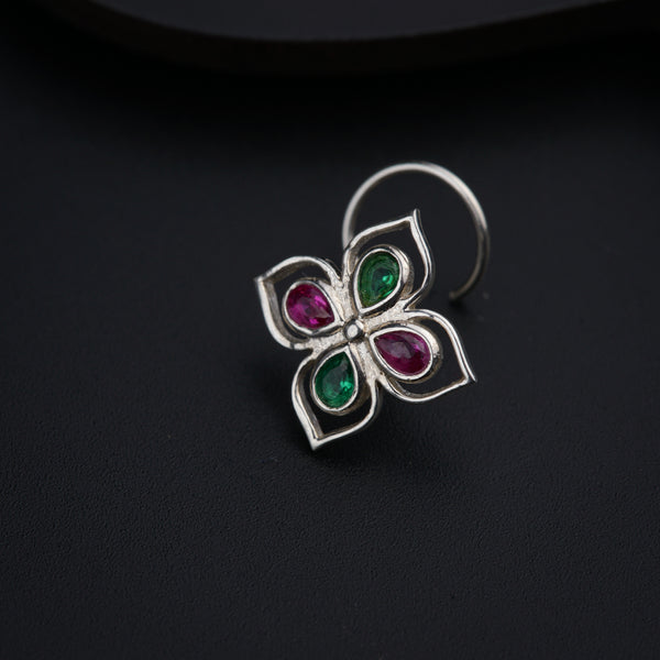 a close up of a flower shaped ring on a black surface