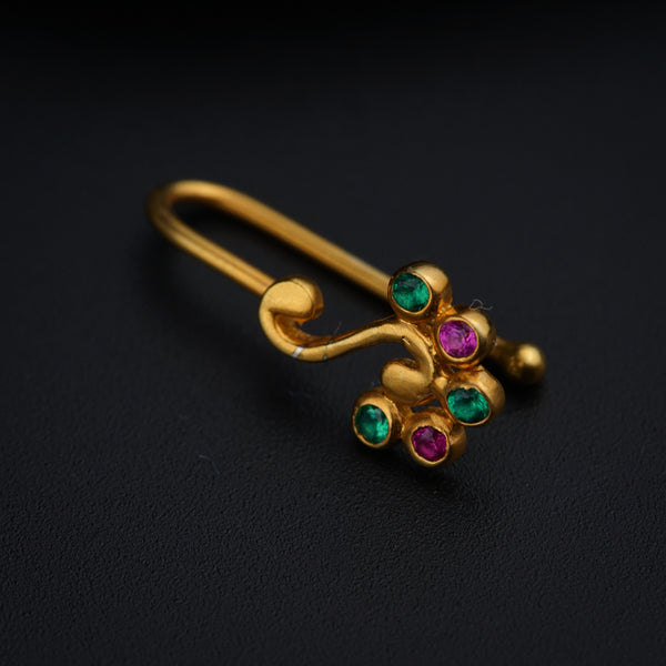 a close up of a gold brooch with multi colored stones