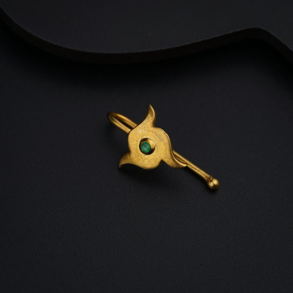 a gold brooch with a green stone on it