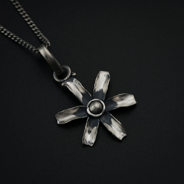 a silver necklace with a flower design on it