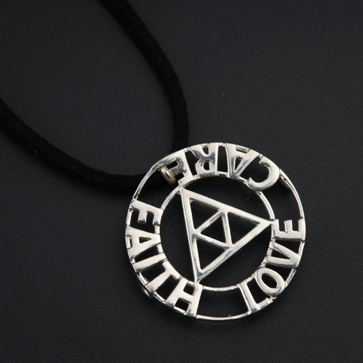 a necklace with a triangle and words on it