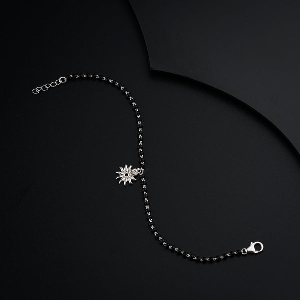 a black beaded necklace on a black surface