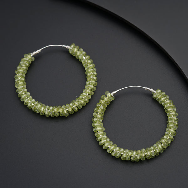 a pair of green beaded hoop earrings