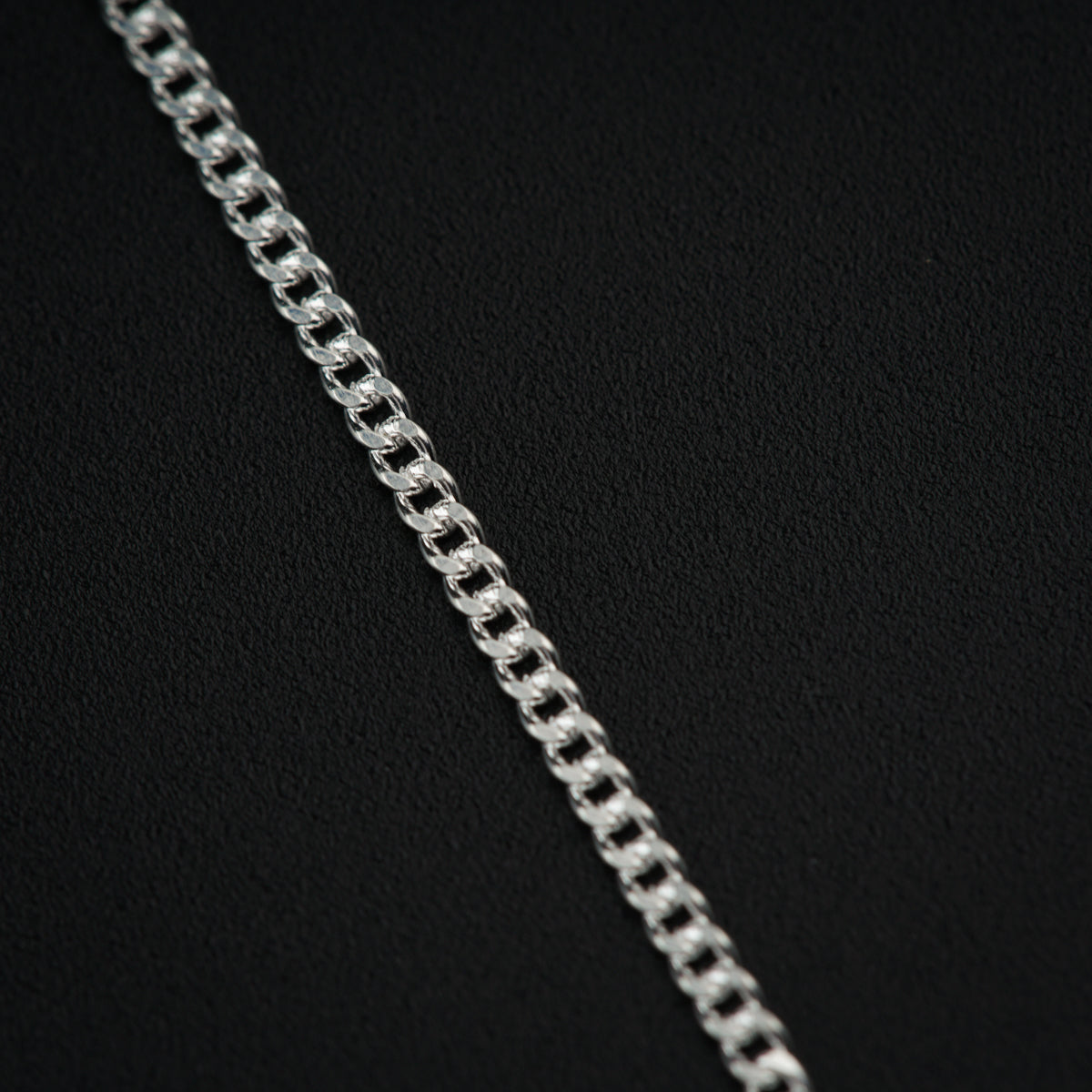 a close up of a silver chain on a black background