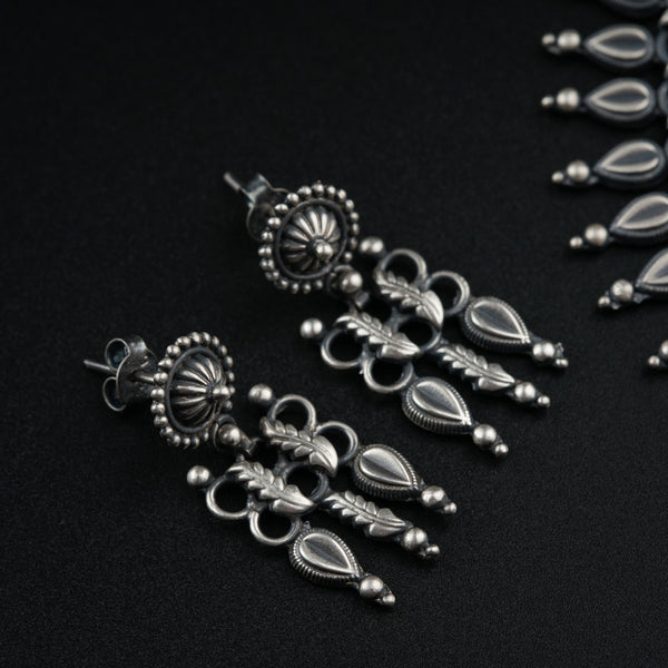 a close up of a pair of earrings on a black surface