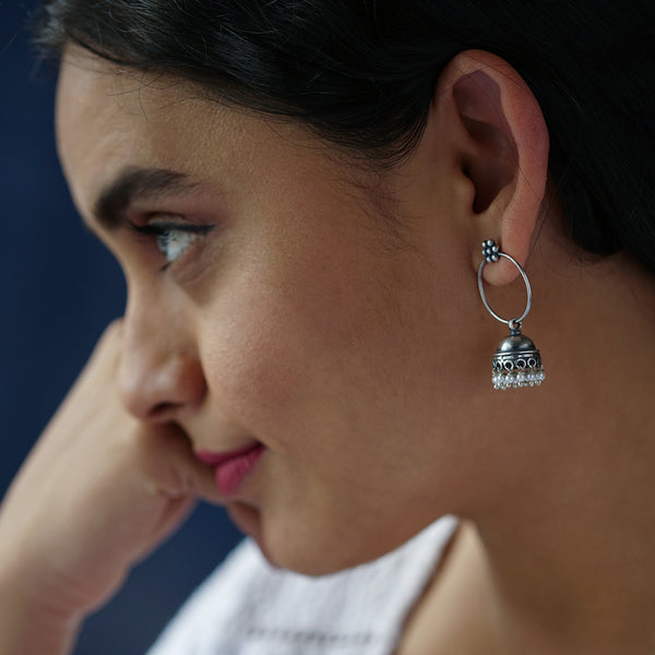 a close up of a person wearing a pair of earrings