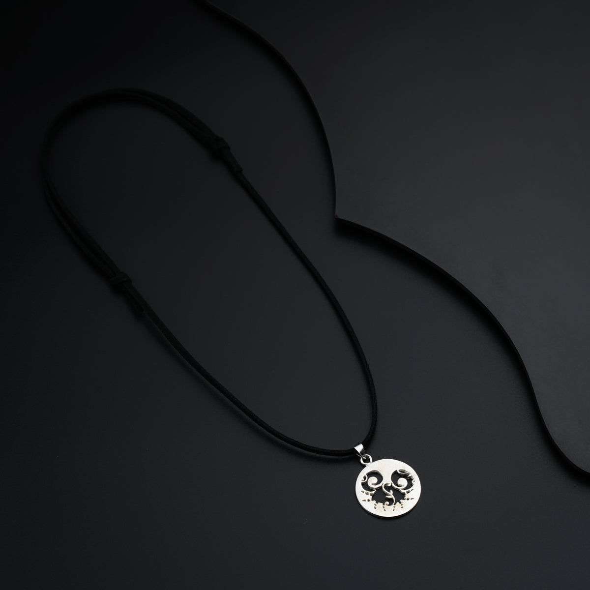 a necklace with a smiley face on a black background
