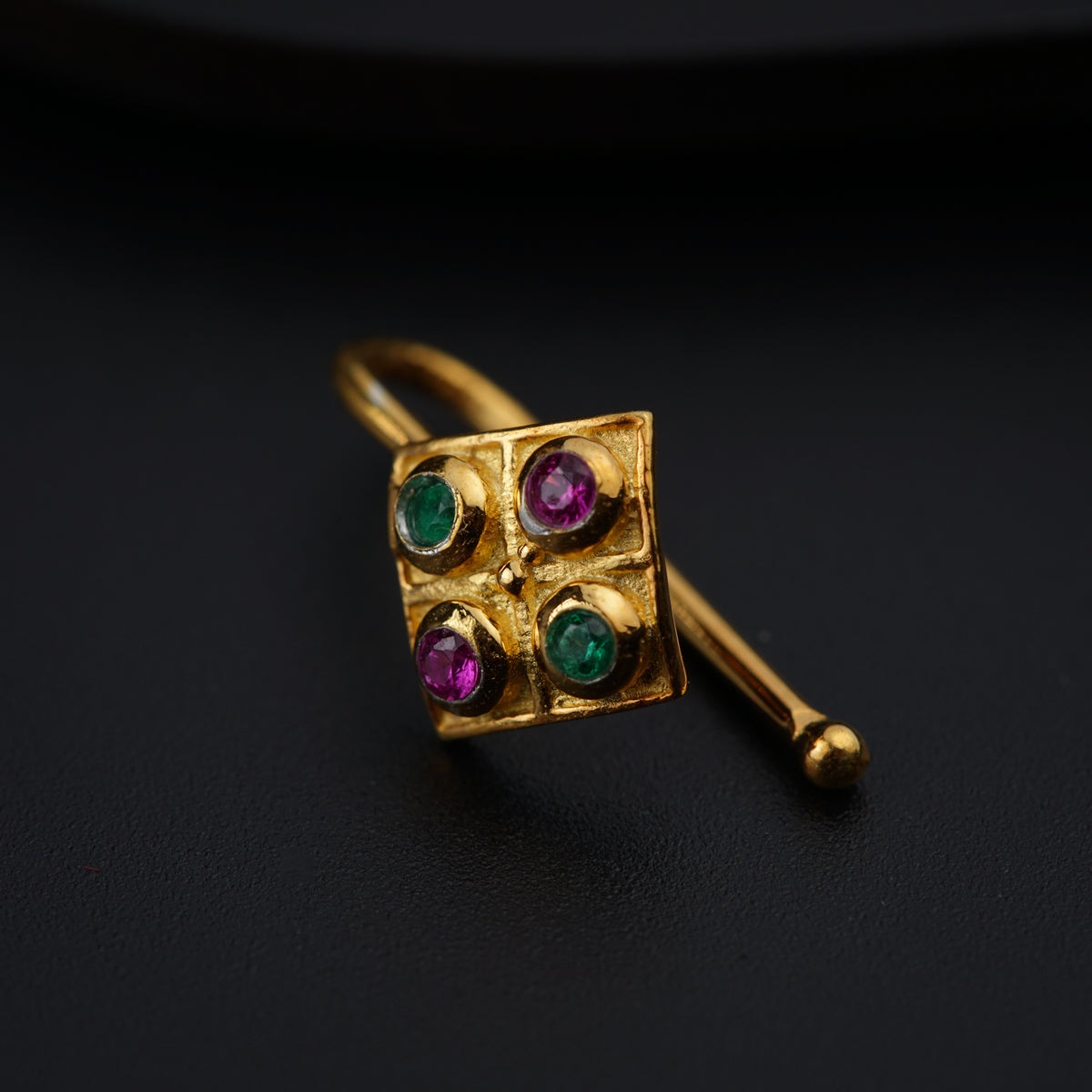 a close up of a gold ring with different colored stones