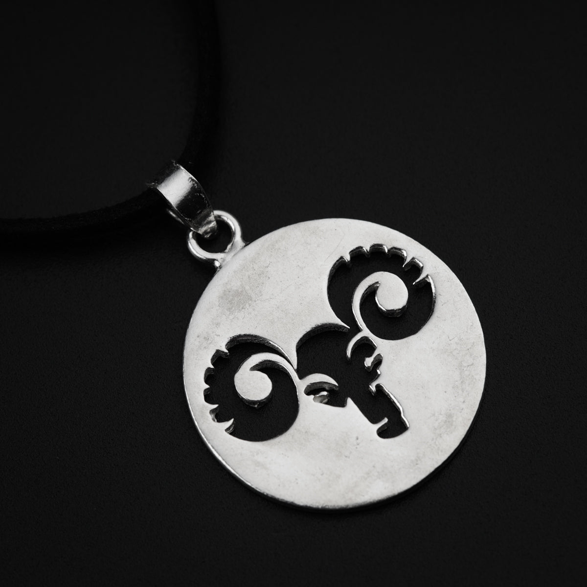 a silver pendant with a ram on it