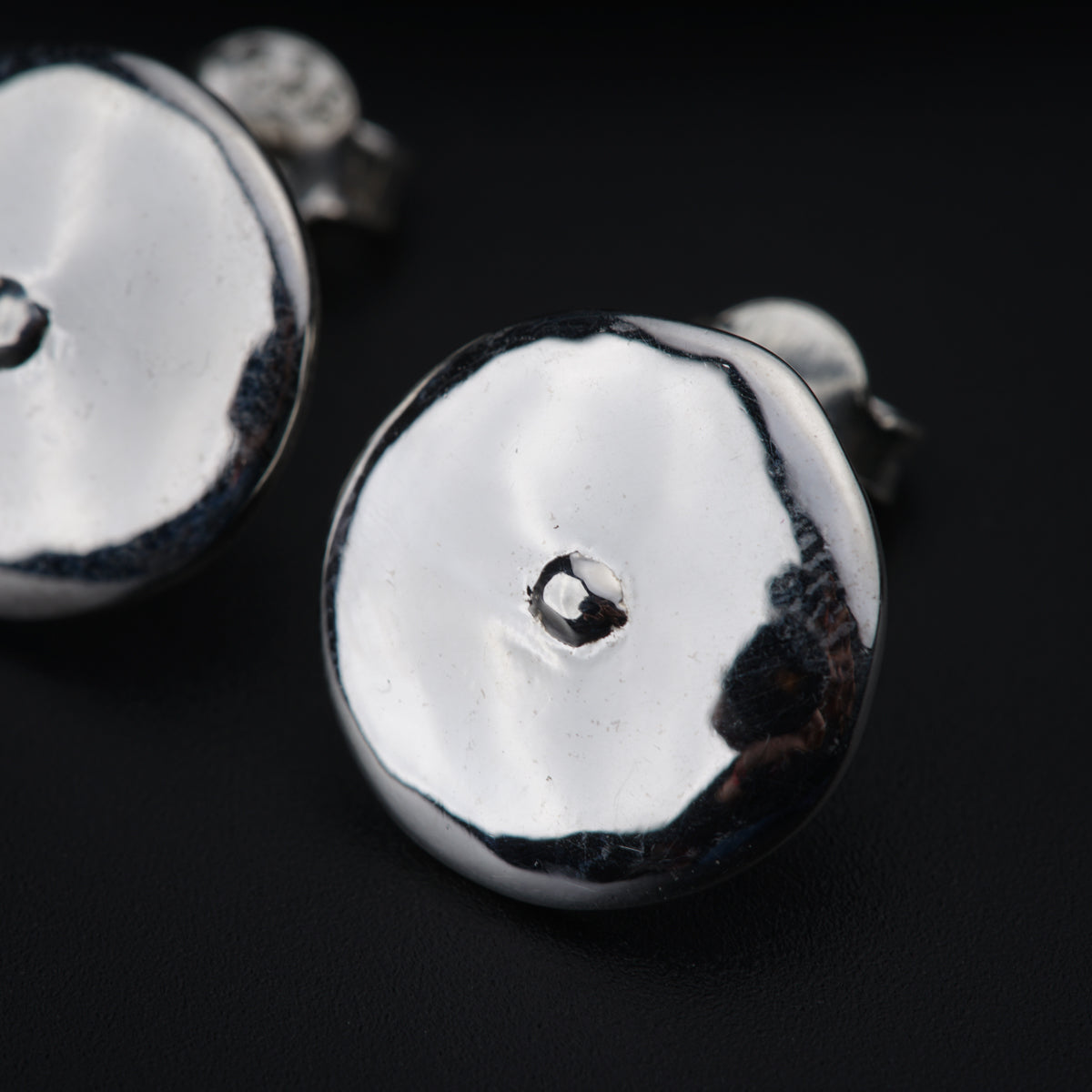a close up of a pair of silver buttons