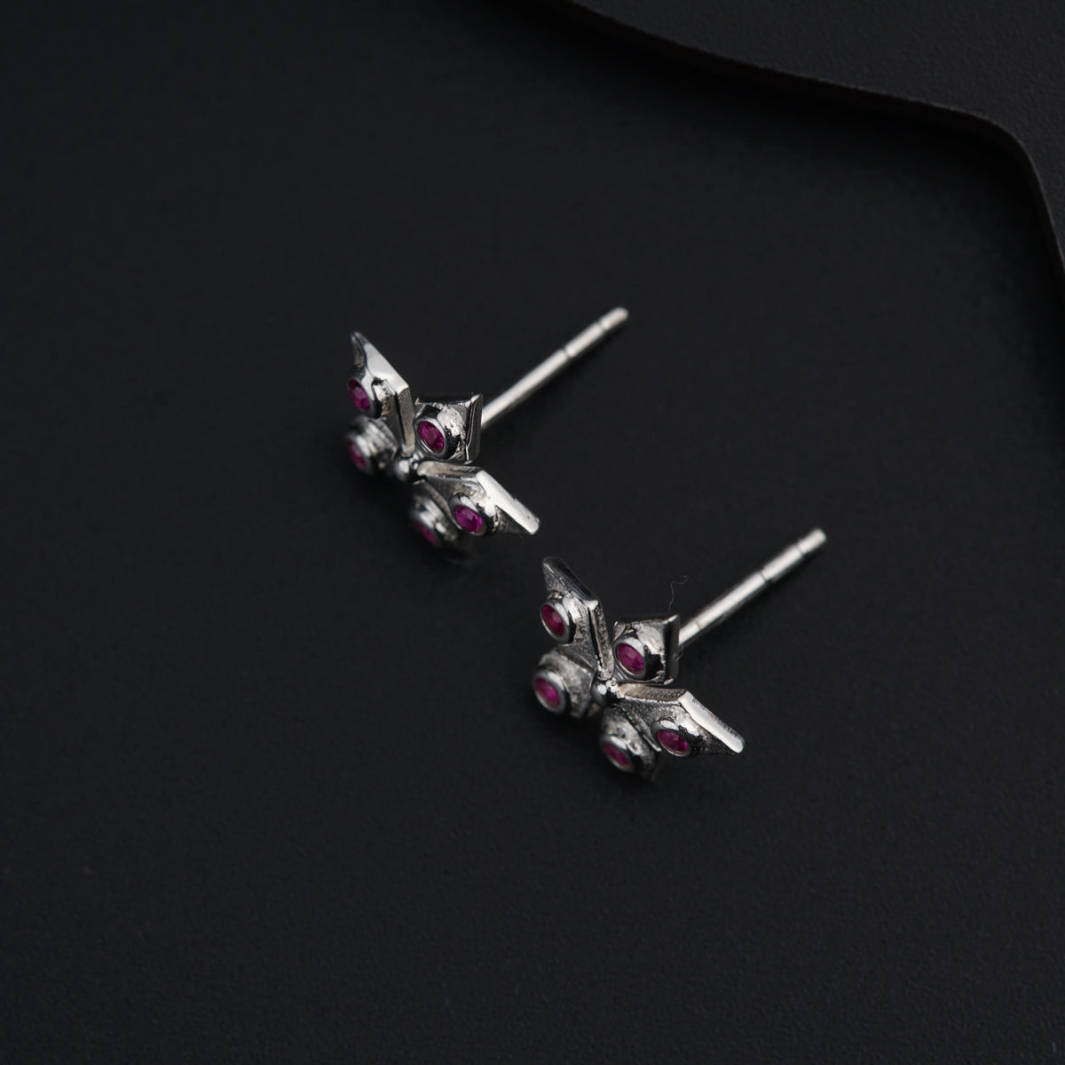 a pair of silver earrings with pink stones