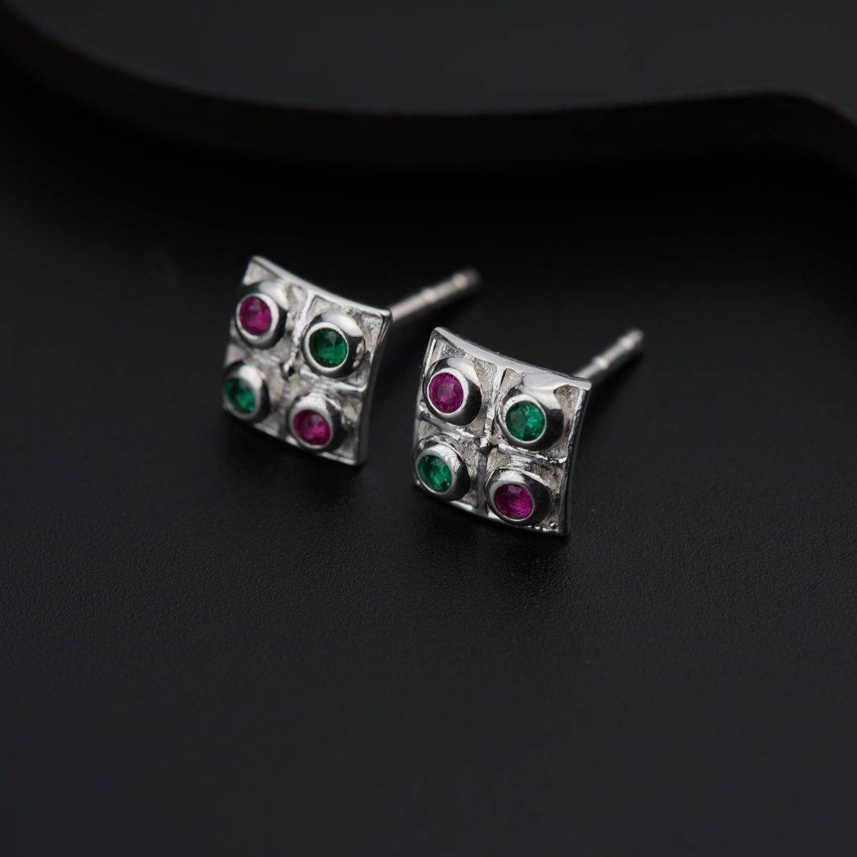 a pair of silver earrings with colored stones