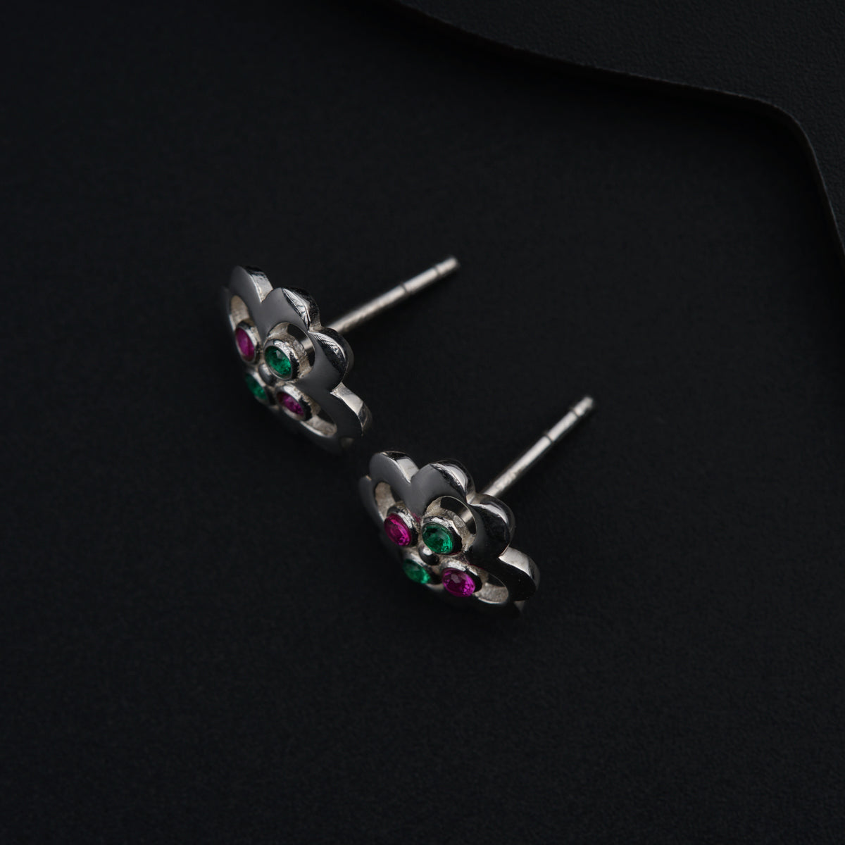 a pair of silver earrings with green and pink stones