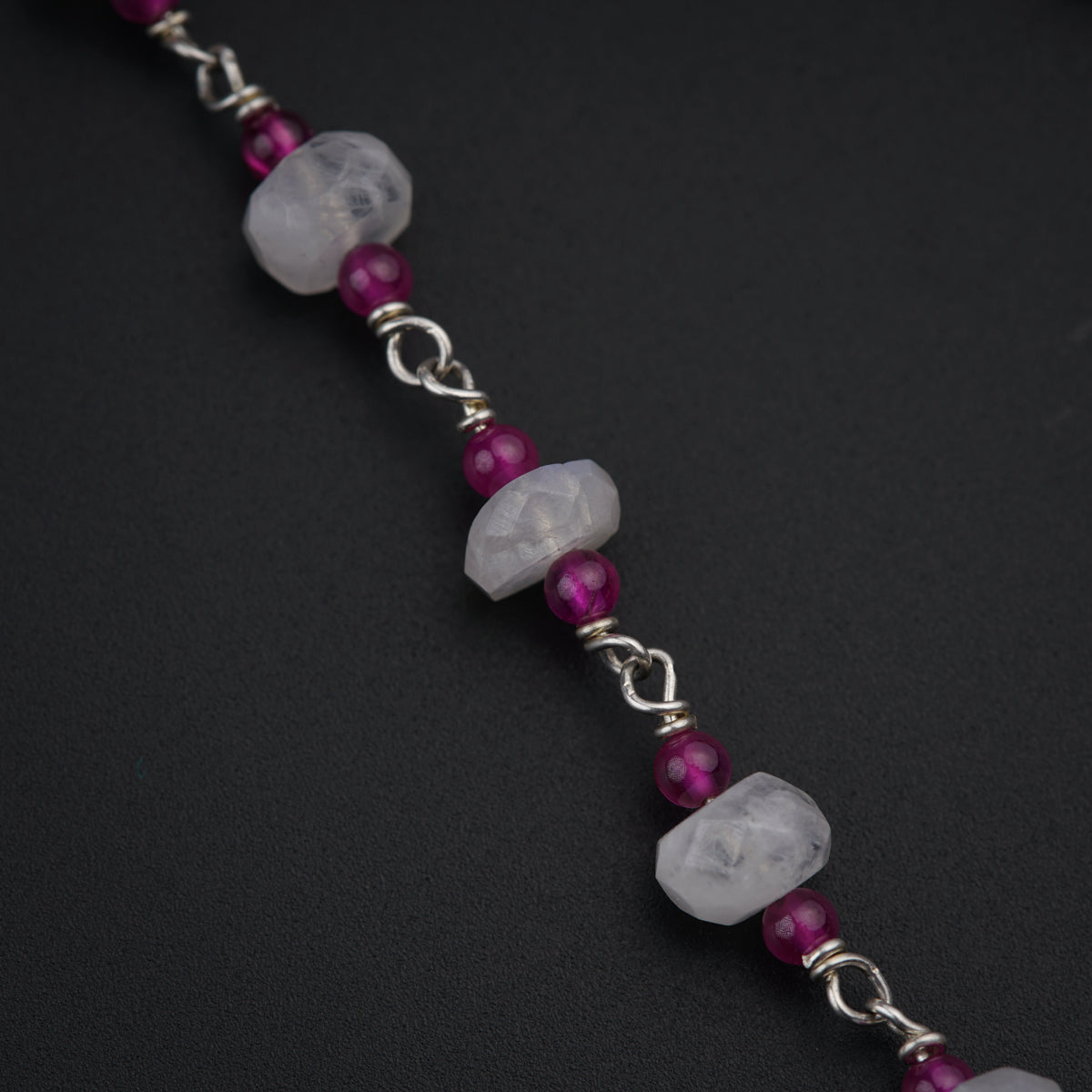 a bracelet with a beaded chain and purple beads