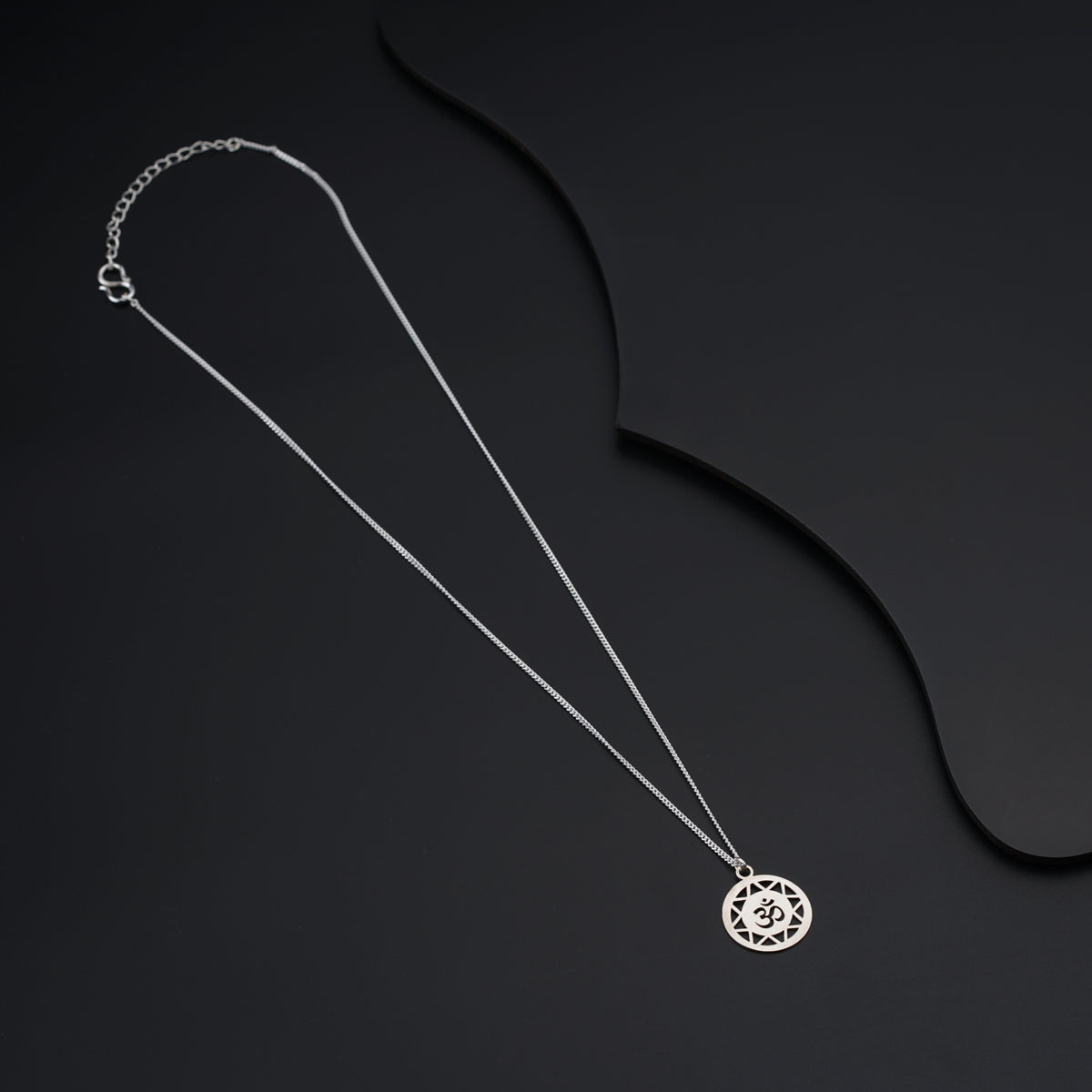 a necklace with a circular pendant on a black background